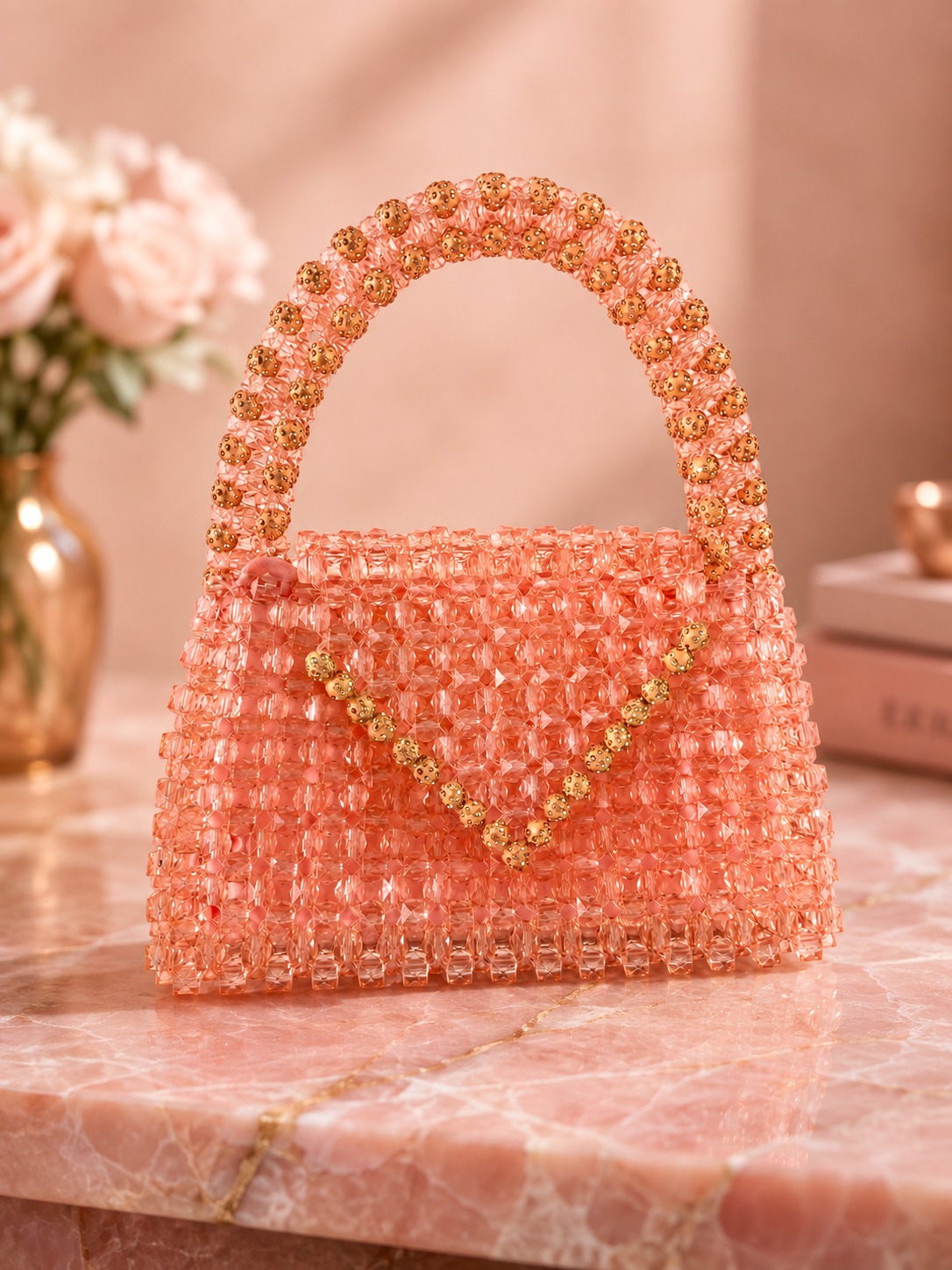 Cartera Durazno de cuentas facetadas con manija y borde dorado